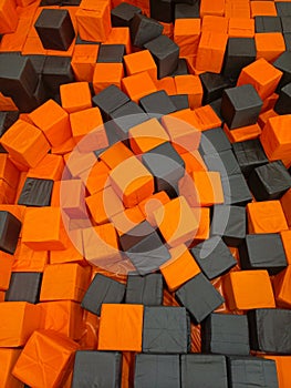Orange and black soft cubes in a game pit with a textured background
