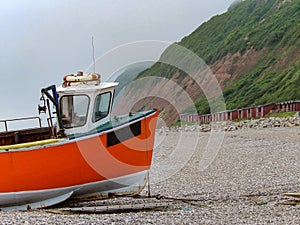 Orange boat on british shingle beach