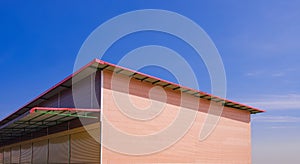 Orange brick pattern of prefabricated smartboard wall with roller shutter doors and steel roof awning of rental shophouse