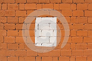 Orange brick wall with painted splotch