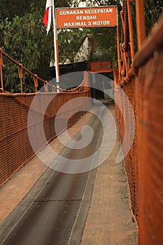 Orange bridge crosses the river to unite two villages