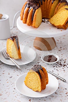 Orange bundt cake topped with chocolate ganache cut into slices