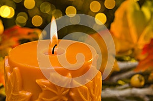 Orange candle in autumn Christmas setting