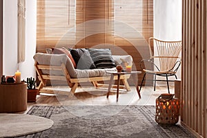 Orange candle on wooden coffee table in cozy living room interior