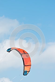 Orange canopy, filled with wind power, to propel a kite board photo
