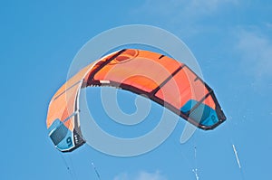 Orange canopy, filled with wind power, to propel a kite board photo