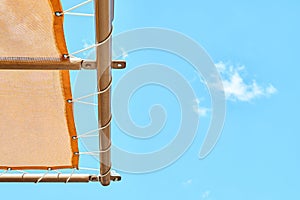 Orange canopy over sun loungers against clear blue sky