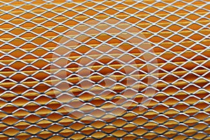 Orange car filter background with iron grille close-up