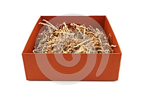 Orange carton box with shredded paper isolated on white background.