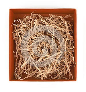 Orange carton box with shredded paper isolated on white background, top view.