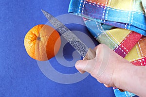 Orange, checkered dishcloth and ceramic knife.