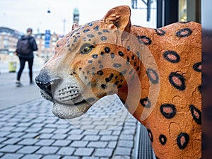 Orange cheetah figurine head sticking out toward the pavement