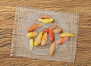 Orange cheiro peppers on a rustic fabric over wooden table. Typical brazilian ingredient photo