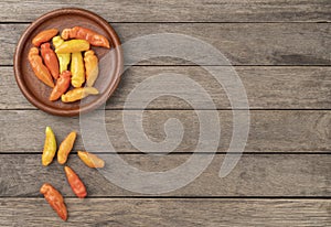 Orange cheiro smell,scent peppers on a plate over wooden table with copy space photo