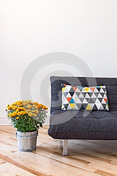 Orange chrysanthemums and sofa with bright cushion