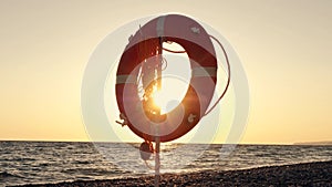 Orange circles of safety on a sea beach in the rays of the setting sun. Slow Motion Picture