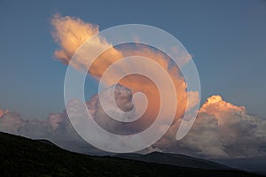 Cirro-cumulus and cumulus clouds in the evening light at sunset in the mountains photo