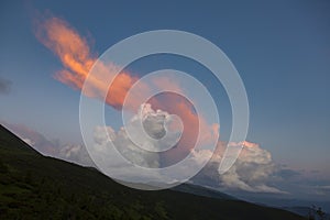 Orange cirro-cumulus and cumulus clouds in the evening light at sunset in the mountains photo