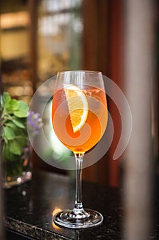 Orange citrus alcoholic drink served in a large transparent glass in a warm locale