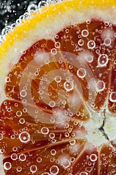 Orange citrus slice falling into water