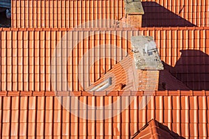 Orange clay tiles on top of a roof .