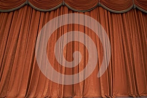 Orange closed curtain or drapes in theater with copy space. Theatrical performance concept.