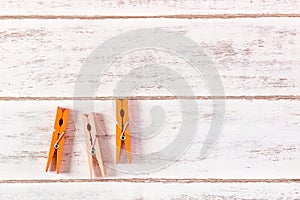 Orange clothes peg on wooden table.