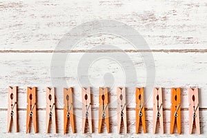 Orange clothes peg on wooden table.