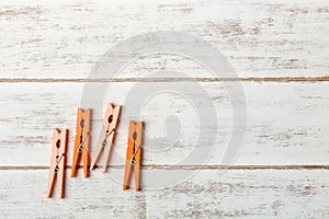 Orange clothes peg on wooden table.