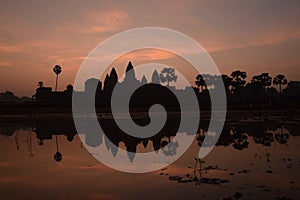 Orange cloud sunrise over famous angkor wat temple with lake and reflection in the water with lillypad