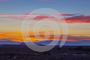 Orange clouds and blue mountains at sunset in the Karoo