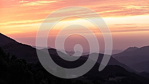 Orange clouds on a mountain landscape sunset sky