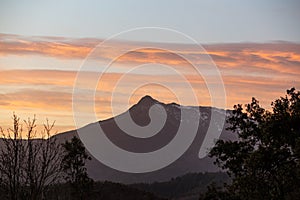 Orange clouds on a mountain landscape sunset sky