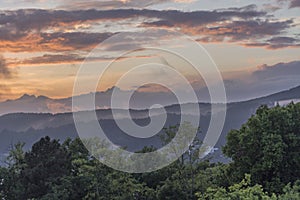 Orange cloudy sky, sunset over mountain