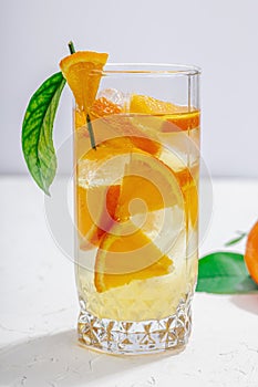 Orange cocktail with ice and ripe fruits. Refreshment seasonal drink, conceptual background