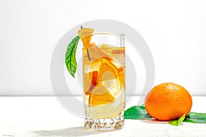 Orange cocktail with ice and ripe fruits. Refreshment seasonal drink, conceptual background