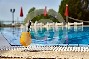 Orange cocktail on poolside outdoor in summer