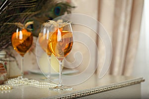 Orange cocktails decorated with physalis on retro table at home interior