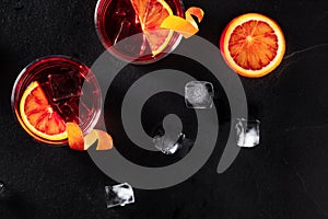 Orange cocktails with ice cubes, top shot on a black background