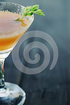 Orange coctail on black wooden table at blurred background