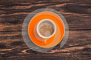 Orange coffee cup on old wooden table