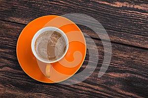 Orange coffee cup on old wooden table