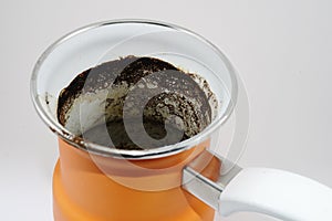 Orange coffee pot with coffee grounds