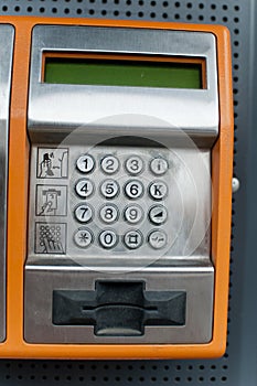 Orange Color Payphone using by call close-up Number Pad