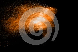 Orange color powder explosion on black background