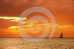 seascape image with shiny sea and sailboat over cloudy sky