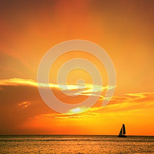 seascape image with shiny sea and sailboat over cloudy sky