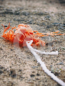 Orange colored fabric on the dirty ground