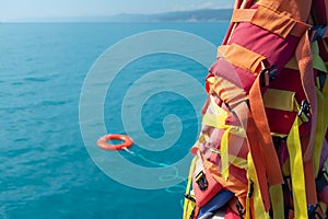 The orange-colored lifebuoy is thrown into the blue sea against the background of the life-rescue