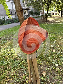 Orange colored straw hat on a tree